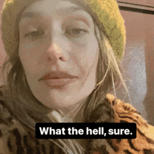 a woman is wearing a yellow hat and a leopard print coat and says what the hell sure