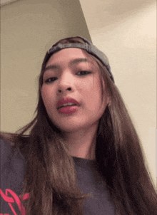a woman wearing a baseball cap and a t-shirt that says ' a ' on it