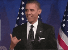 a man in a suit and tie giving a shaka sign