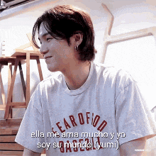 a young man wearing a t-shirt that says ella me ama mucho y yo soy su mundo .