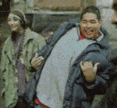 a man in a blue jacket is standing next to a woman in a green coat