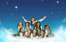 a group of girls laying on a cloud with their arms in the air