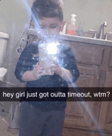a young boy taking a picture of himself in a bathroom mirror with the caption " hey girl just got outta time out wtm "