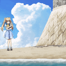 a girl in a blue dress is standing on a sandy beach
