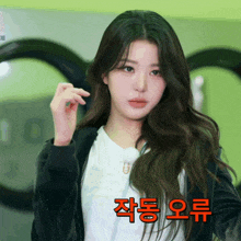 a woman in a black jacket stands in front of a laundromat machine with korean writing on the bottom
