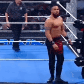 a wrestler is standing in a ring with a referee behind him