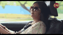 a woman wearing sunglasses sits in the back seat of a car with a sticker on the headrest that says " dega "