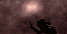 a silhouette of a person in a dark cloudy sky with a lightning bolt .
