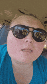 a woman wearing sunglasses has a reflection of a school bus