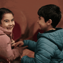 a boy and a girl are smiling at each other