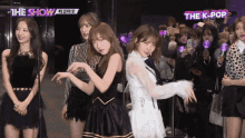 a group of girls are standing in front of a crowd with the show written on the top left