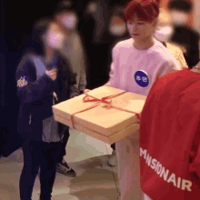 a person wearing a missionair shirt holds a box