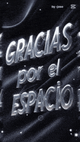 gracias por el espacio is written in silver letters on a black background