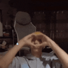 a man is making a heart shape with his hands