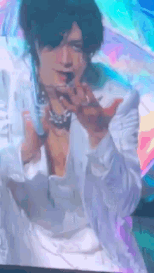 a man in a white shirt is singing into a microphone