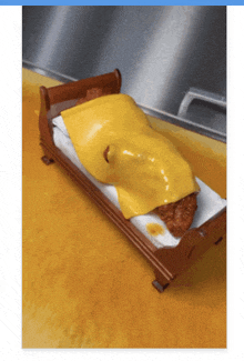 a bed with cheese and a piece of meat on it