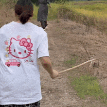 a woman wearing a white shirt with a hello kitty design on it