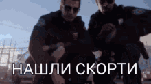 two police officers standing next to each other with the words " нашли скорти " written in white