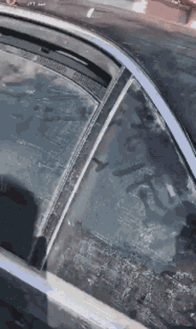a close up of a car window with a reflection of a building