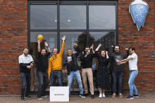 a group of people standing in front of a brick building with a box that says ' antwerpia ' on it