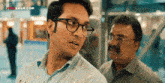 a man wearing glasses is standing next to another man with a videosaur.com logo on the bottom