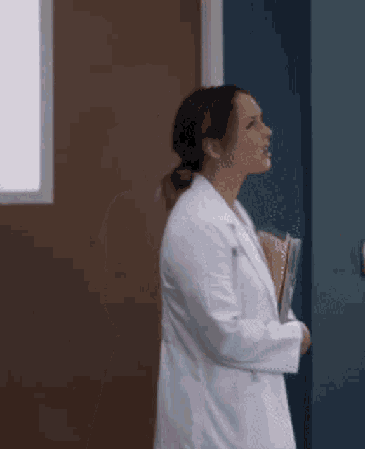 a woman in a lab coat is holding a folder