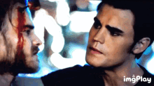 a man with blood on his face is looking at another man