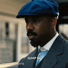 a man in a suit and blue hat is jumping in