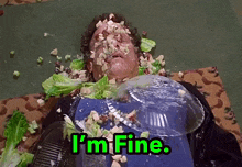 a man is laying on the floor with a plate of food on his face and the words i 'm fine above him