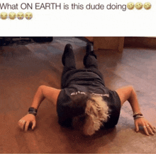 a man is doing push ups on the floor with the caption what on earth is this dude doing
