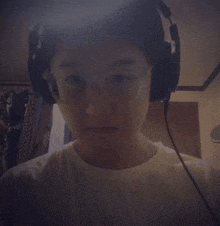 a person wearing headphones and glasses is looking at the camera