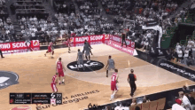 a basketball game is being played in front of a crowd with ads for radio scoop