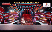 a man and woman are dancing on a stage with behindwoods written on it