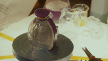 a glass bottle with a purple lid that says ' liberty ' on it