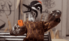 a stuffed bird is taking a selfie with a phone