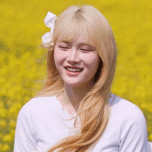 a woman with blonde hair and a white bow in her hair is smiling