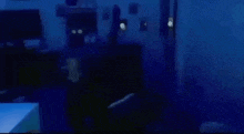 a person is standing in a dark room with a blue light shining on them .