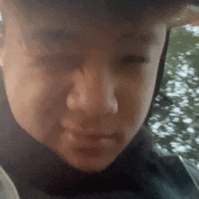 a close up of a person 's face with a black hat on