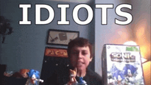 a boy is holding a sonic the hedgehog toy in front of a sonic video game