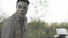 a man wearing glasses and a shirt with the word little on the bottom left