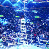 a woman stands on a ladder in front of a crowd at a wheatley wrestling event