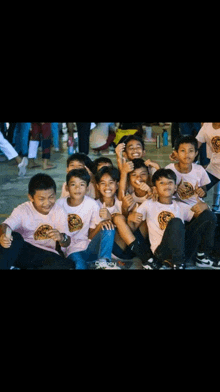 a group of young boys wearing pink shirts with a lion on them are posing for a photo