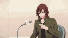 a man with long red hair is sitting in front of a microphone .