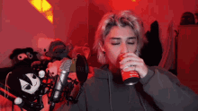 a woman drinking from a red can that says coca cola