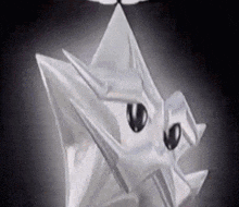 a close up of a cartoon character made out of a piece of paper with black eyes .