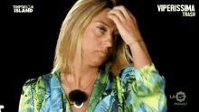 a woman is holding her head in front of a temptation island sign