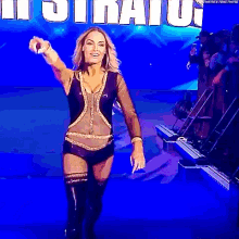 a woman is walking on a stage in front of a sign that says ' ii stratus ' on it .