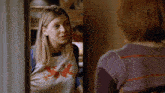a woman wearing a t-shirt that says x is talking to another woman