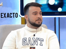 a man wearing a white sweater that says gant