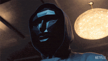 a person wearing a mask and a hoodie with netflix written on it